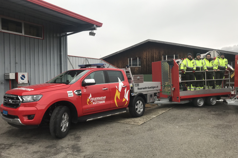 Ein Detachement der Feuerwehr Küttigen auf dem frisch abgeholten Schlauchverlegeanhänger